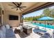 Relaxing covered patio area with a fireplace, comfortable seating, and a pool view at 8766 Capstone Ranch Dr, New Port Richey, FL 34655