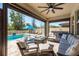 Relaxing covered patio with plush seating, a fireplace, a fan, and a view of the pool at 8766 Capstone Ranch Dr, New Port Richey, FL 34655