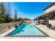 An inviting backyard pool with in-pool loungers and an outdoor covered patio area at 8766 Capstone Ranch Dr, New Port Richey, FL 34655