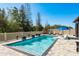 Inviting backyard pool features in-pool loungers and decorative fire bowls near the manicured fence at 8766 Capstone Ranch Dr, New Port Richey, FL 34655