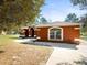 Exterior shot of home showcasing its architectural details, walkway, and landscaping at 9130 Madrid Rd, Weeki Wachee, FL 34613