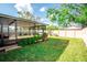 A spacious, landscaped backyard with a screened patio, offering a perfect blend of indoor and outdoor living at 17113 Sunshine Mimosa St, Wimauma, FL 33598