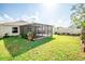 Expansive backyard features a screened patio, lush greenery, and a garden area, creating a private outdoor oasis at 17113 Sunshine Mimosa St, Wimauma, FL 33598