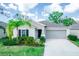 Charming single-story home with a well-manicured lawn, a two-car garage, and lush landscaping at 17113 Sunshine Mimosa St, Wimauma, FL 33598