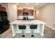 Modern kitchen island featuring bar stool seating, stainless steel appliances, and wood cabinetry at 17113 Sunshine Mimosa St, Wimauma, FL 33598
