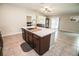Spacious kitchen island with a sink, cabinets, and an open view into the living room at 17113 Sunshine Mimosa St, Wimauma, FL 33598