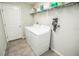 Functional laundry room with washer, dryer, shelving, and easy access to the rest of the home at 17113 Sunshine Mimosa St, Wimauma, FL 33598