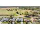 Aerial view of a home in a quiet suburban neighborhood with green spaces and mature trees at 10216 Moshie Ln, San Antonio, FL 33576