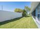 Backyard showcasing the white privacy fence and lush, grassy lawn at 10216 Moshie Ln, San Antonio, FL 33576