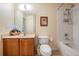 Bathroom featuring a vanity, commode and a shower-tub combination with tiled walls at 10216 Moshie Ln, San Antonio, FL 33576