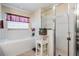 Bright bathroom with a soaking tub, separate shower stall, and white tile finishes at 10216 Moshie Ln, San Antonio, FL 33576