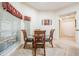 Bright dining area featuring tile flooring, a glass-top table, and a large window with blinds at 10216 Moshie Ln, San Antonio, FL 33576