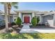 Charming home featuring a red double-door entrance, manicured bushes, and a well-maintained landscaped front yard at 10216 Moshie Ln, San Antonio, FL 33576