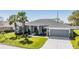 Beautiful single-story home featuring a well-manicured lawn, mature palm trees, and a two-car garage at 10216 Moshie Ln, San Antonio, FL 33576
