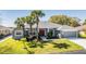 Charming single-story home featuring a well-manicured lawn and mature palm trees in a peaceful neighborhood at 10216 Moshie Ln, San Antonio, FL 33576