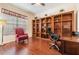 Dedicated office space featuring wood floors, built-in bookshelves, and a comfortable workspace at 10216 Moshie Ln, San Antonio, FL 33576