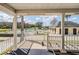 View of community pool from the porch with tables, chairs, and umbrellas for a comfortable visit at 10216 Moshie Ln, San Antonio, FL 33576