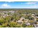 Aerial shot of a neighborhood featuring green trees, well-maintained homes, and a pool, under a clear blue sky at 106 Indian Rocks S Rd, Belleair Bluffs, FL 33770