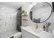 Modern bathroom featuring geometric shower tiles, floating shelves and a round mirror at 1110 S Pine Lake Dr, Tampa, FL 33612