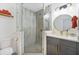 Modern bathroom featuring a glass-enclosed shower, gold fixtures, and gray vanity at 1110 S Pine Lake Dr, Tampa, FL 33612