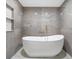 Modern bathroom featuring stone tile, a freestanding tub, and recessed lighting at 1110 S Pine Lake Dr, Tampa, FL 33612