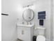 Bright bathroom with a round mirror, modern hardware and a toilet at 1110 S Pine Lake Dr, Tampa, FL 33612