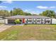 Charming home with an eye-catching red door, modern paint, a well-manicured lawn, and a beautiful landscape design at 1110 S Pine Lake Dr, Tampa, FL 33612