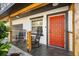 Charming front porch with stylish tile flooring, rocking chairs, and a vibrant red door at 1110 S Pine Lake Dr, Tampa, FL 33612