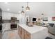 Modern kitchen featuring an island with seating, stainless steel appliances, decorative backsplash, and an open layout at 1110 S Pine Lake Dr, Tampa, FL 33612