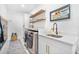 Well-lit laundry room featuring modern washer and dryer at 1110 S Pine Lake Dr, Tampa, FL 33612