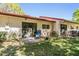 A serene backyard featuring a patio with outdoor seating, green grass, and the property's exterior at 1159 Montrose Pl, Dunedin, FL 34698