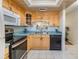 Traditional kitchen featuring wood cabinets, updated appliances, and a window over the double sink at 1159 Montrose Pl, Dunedin, FL 34698