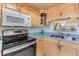 Well-lit kitchen features light wood cabinetry, modern appliances, and a pass-through window above the sink at 1159 Montrose Pl, Dunedin, FL 34698