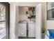 Functional laundry closet with louvered doors, a stacked washer and dryer, and storage shelves at 1159 Montrose Pl, Dunedin, FL 34698