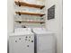 Bright laundry room featuring modern washer and dryer, open shelving, and playful decor at 12812 Buffalo Run Dr, Gibsonton, FL 33534