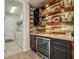Home wet bar with wine storage, mini fridge, custom cabinets, and unique design at 13822 Carlow Park Dr, Riverview, FL 33579
