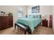 Cozy bedroom with warm lighting, hardwood floors, bench, and a comfortable queen size bed at 13822 Carlow Park Dr, Riverview, FL 33579