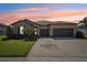 Well-maintained exterior features a manicured lawn and a two-car garage at sunset at 13822 Carlow Park Dr, Riverview, FL 33579