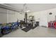 Bright garage featuring a home gym, motorcycle, and epoxy flooring at 13822 Carlow Park Dr, Riverview, FL 33579