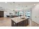 Open kitchen with stainless appliances, center island with barstool seating, and seamless flow to living spaces with water views at 13822 Carlow Park Dr, Riverview, FL 33579