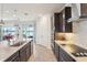 Spacious kitchen featuring modern appliances, an island with bar seating, and views of the outdoors with a seamless open floorplan at 13822 Carlow Park Dr, Riverview, FL 33579