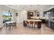 Open kitchen with stainless appliances, island with breakfast bar, pendant lights, and adjacent dining area with large windows at 13822 Carlow Park Dr, Riverview, FL 33579