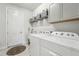 Well-organized laundry room with washer, dryer, and built-in storage shelves and cabinets at 13822 Carlow Park Dr, Riverview, FL 33579