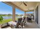 Screened-in patio with lounge chairs and a summer kitchen overlooking the lake at 13822 Carlow Park Dr, Riverview, FL 33579