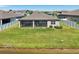 Back exterior view of a home featuring a screened-in lanai overlooking a scenic lake at 13822 Carlow Park Dr, Riverview, FL 33579