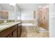 Luxurious bathroom with separate tub and shower, granite vanity, and tile floor at 15414 Fire Rock Pl, Ruskin, FL 33573