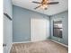 Bedroom with blue walls, carpet, ceiling fan, and double-door closet at 15414 Fire Rock Pl, Ruskin, FL 33573