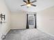 Comfortable bedroom with plush carpet, ceiling fan, and large window with curtains at 15414 Fire Rock Pl, Ruskin, FL 33573
