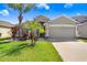 Charming single-story home with well-manicured lawn, landscaping, and attached two-car garage at 15414 Fire Rock Pl, Ruskin, FL 33573