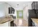 Modern kitchen featuring granite countertops, stainless steel appliances, and a neutral tile floor at 15414 Fire Rock Pl, Ruskin, FL 33573
